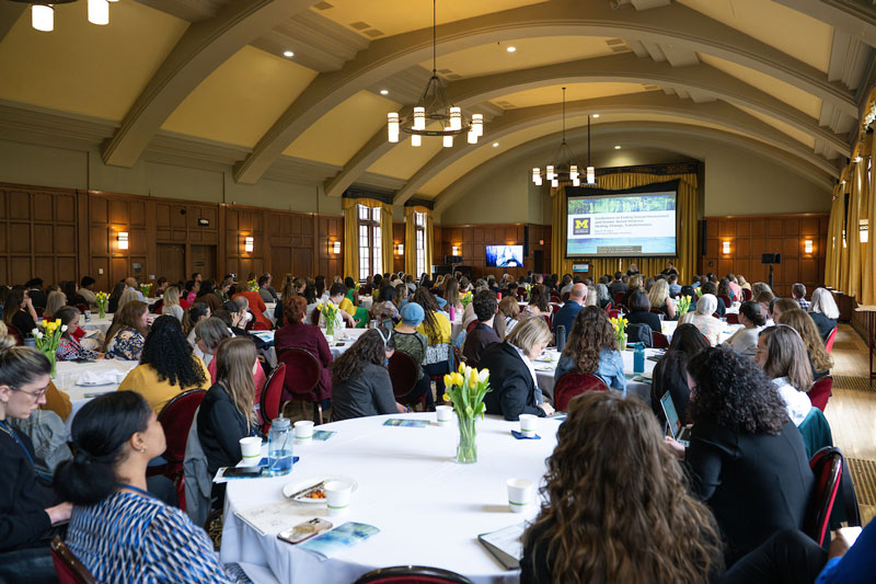 A roomful of people seated at round table during the first Conference on Ending Sexual Harassment and Gender-Based Violence inside the Michigan League.